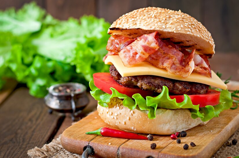 The bacon is usually crispy and added on top of the cheese and beef patties